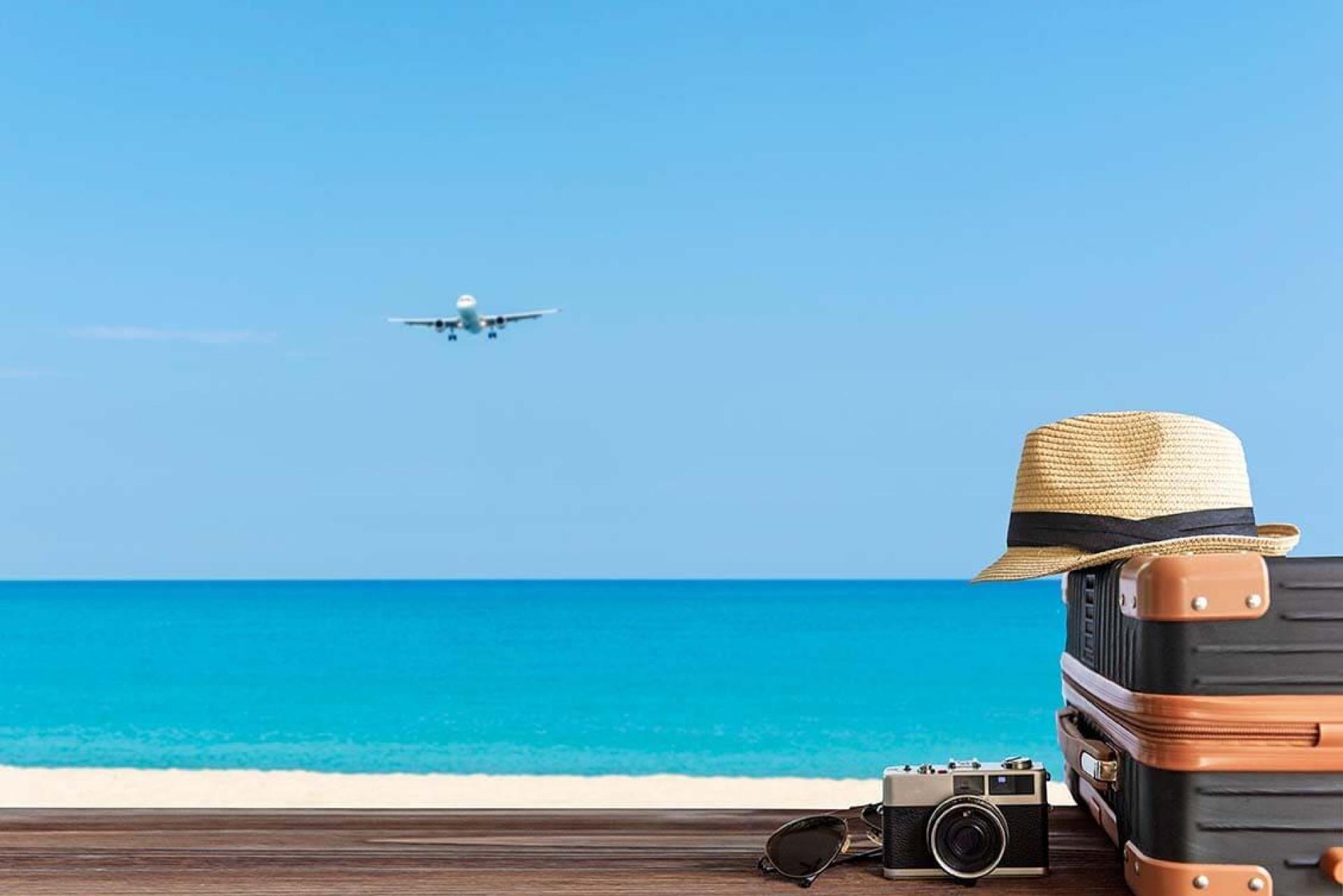 plage, avion, appareil-photo, chapeau et valise symbolisant les vacances