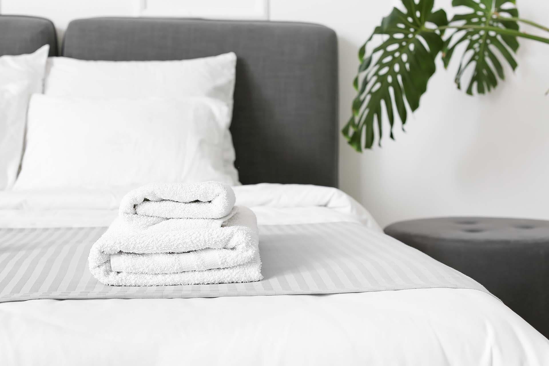 zoom sur un lit et des serviettes de bain pliées