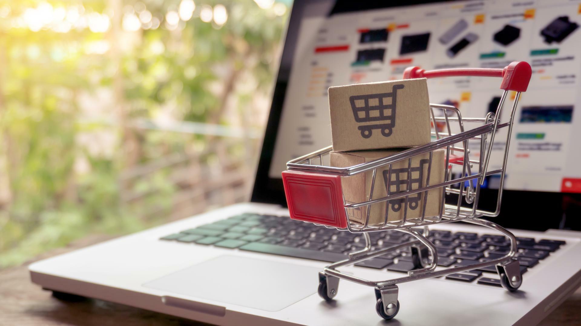 ordinateur portable et mini chariot illustrant les achats sur internet