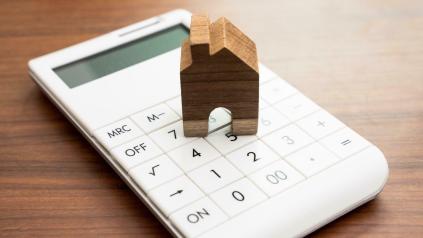 petite maison en bois sur une calculatrice symbolisant les loyers